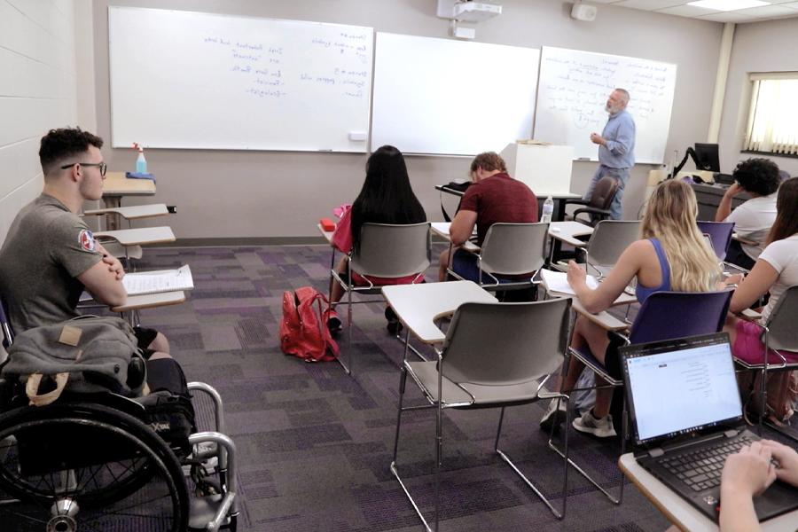 A faculty member teaches at a whiteboard.